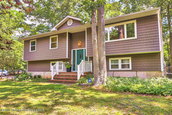 271 Jackson Pines Road Jackson, NJ 08527 - Photo 1 of 26 a front view of a house with a garden and plants