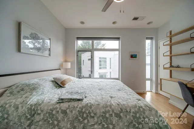 a bedroom with a bed and a large window