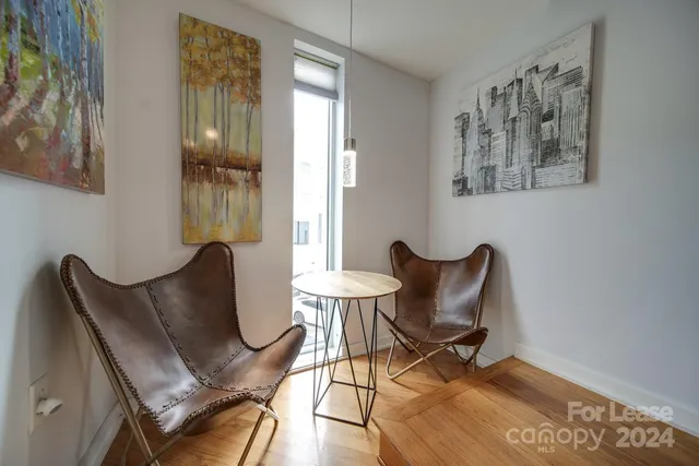 a view of a livingroom with lounge chair and a large window