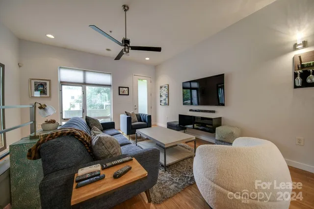 a living room with furniture a window and a flat screen tv
