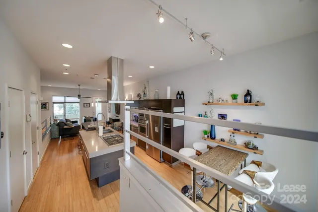 a large white kitchen with lots of counter space and stainless steel appliances