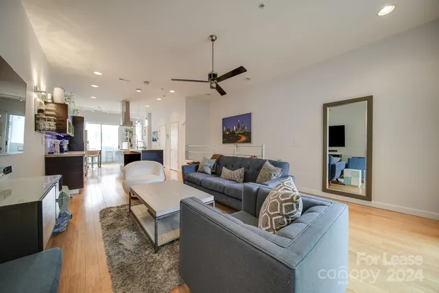 a living room with furniture and a wooden floor
