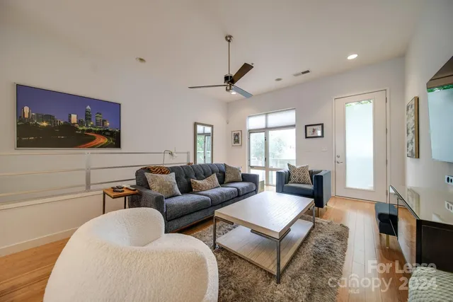 a living room with furniture a flat screen tv and a window