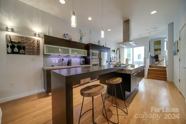 a kitchen with stainless steel appliances kitchen island granite countertop a stove a sink and a microwave