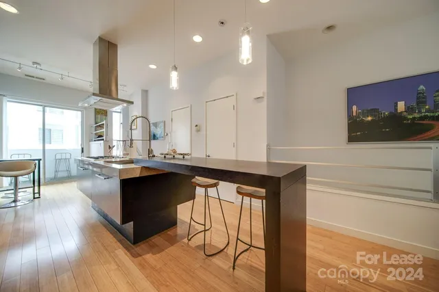a kitchen with stainless steel appliances granite countertop a sink a stove and a wooden floors
