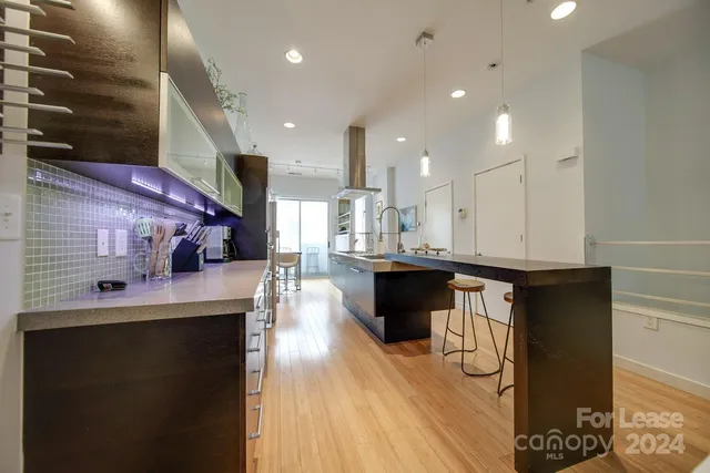 a kitchen with stainless steel appliances kitchen island granite countertop a stove a sink and a refrigerator