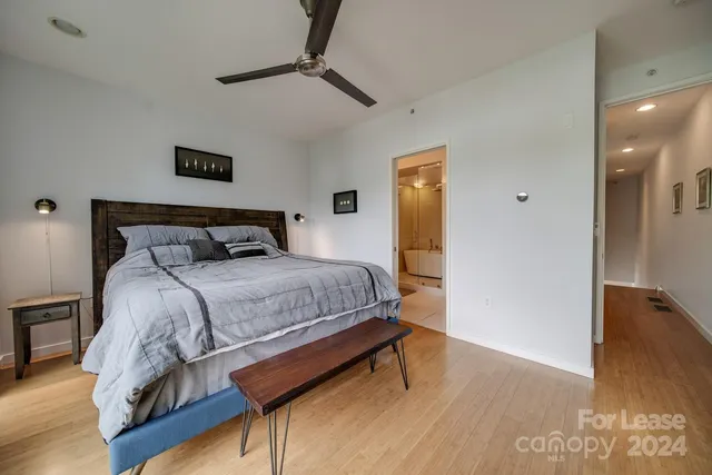 a bedroom with a bed and wooden floor