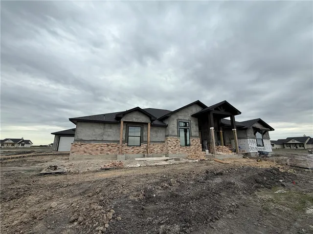 a front view of a house with large trees