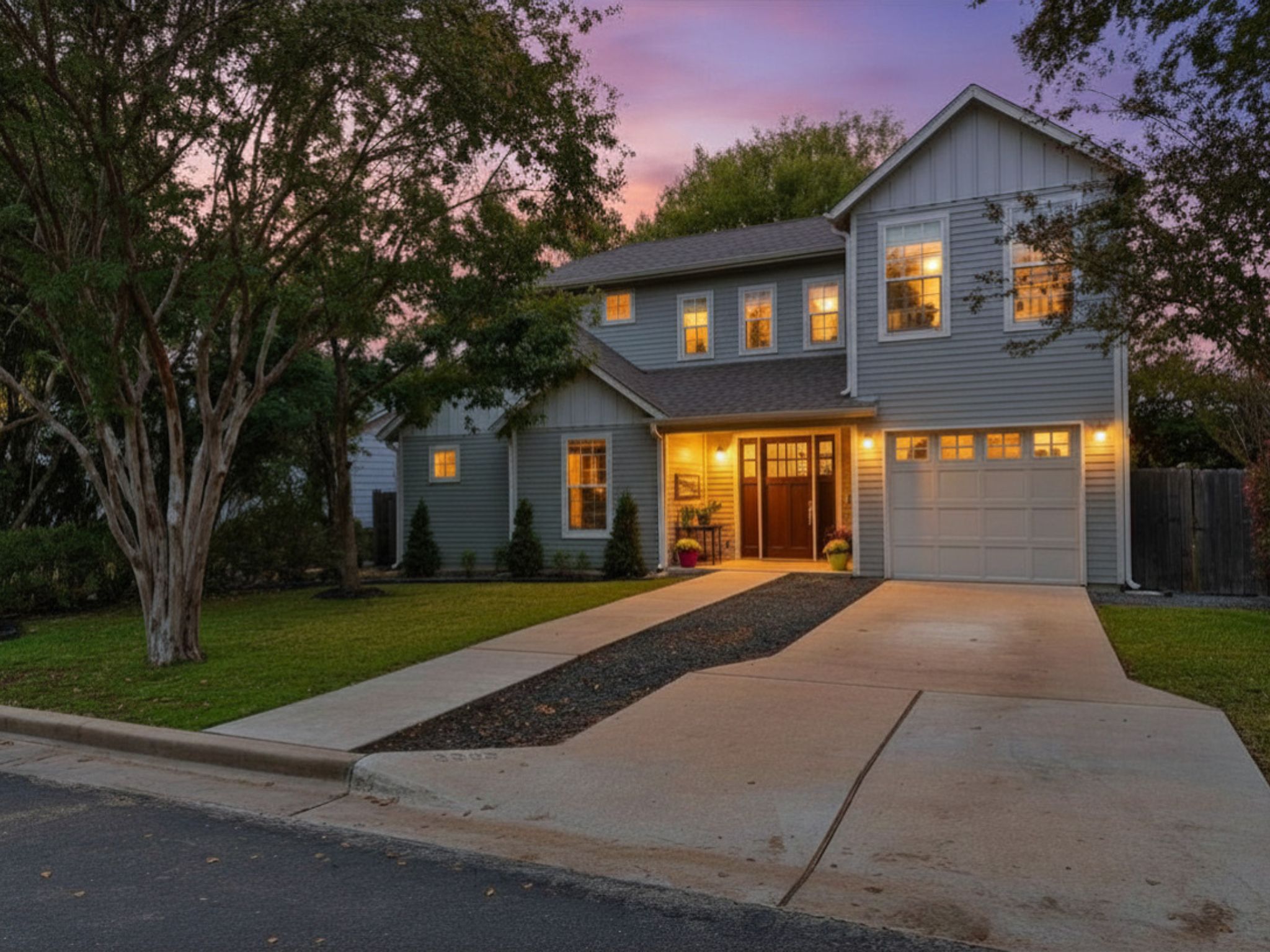3302 Funston Street Austin, TX 78703 - Photo 2 of 36 Contemporary two-story residence featuring light gray siding, a prominent two-car garage, and a concrete driveway with a central gravel accent