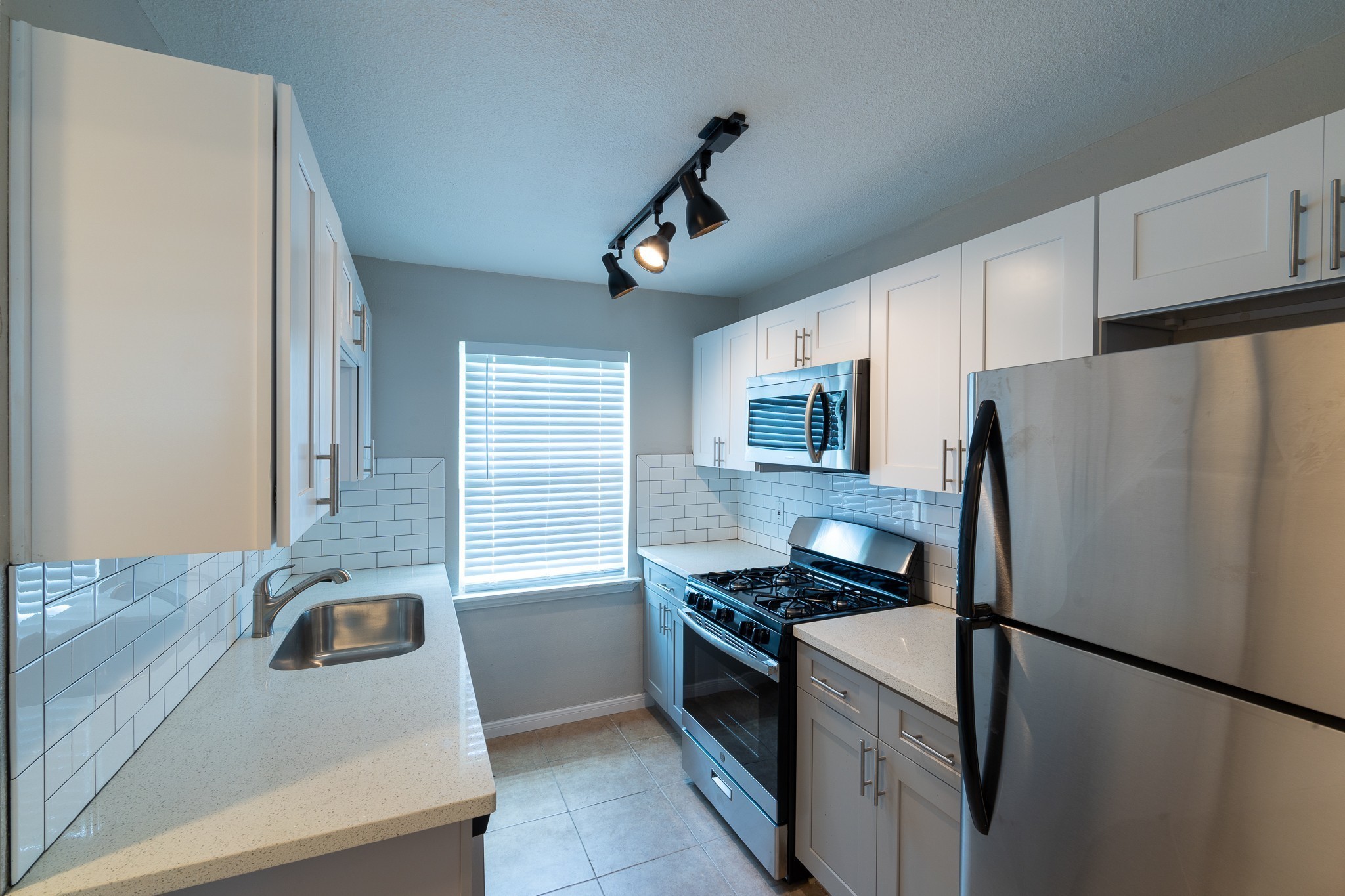 2503 Delano Street, Unit 4 Houston, TX 77004 - Photo 2 of 10 a kitchen with granite countertop a refrigerator and a sink