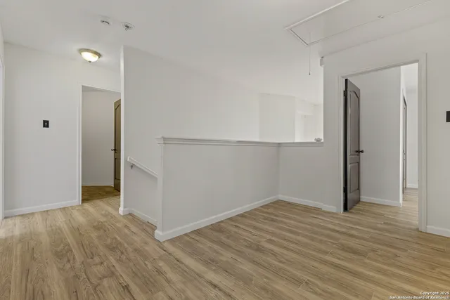 an empty room with wooden floor and entrance