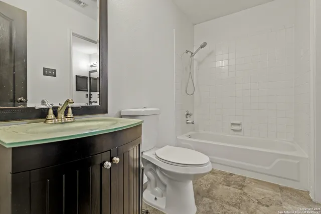 a bathroom with a granite countertop sink toilet and shower
