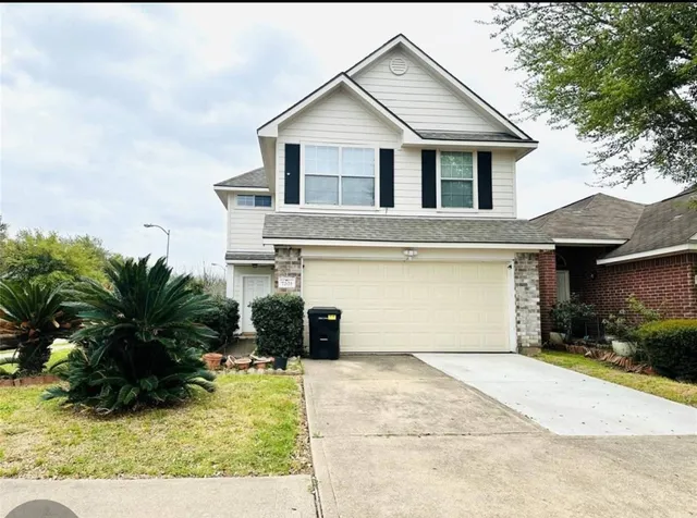 a front view of a house with a yard and garage