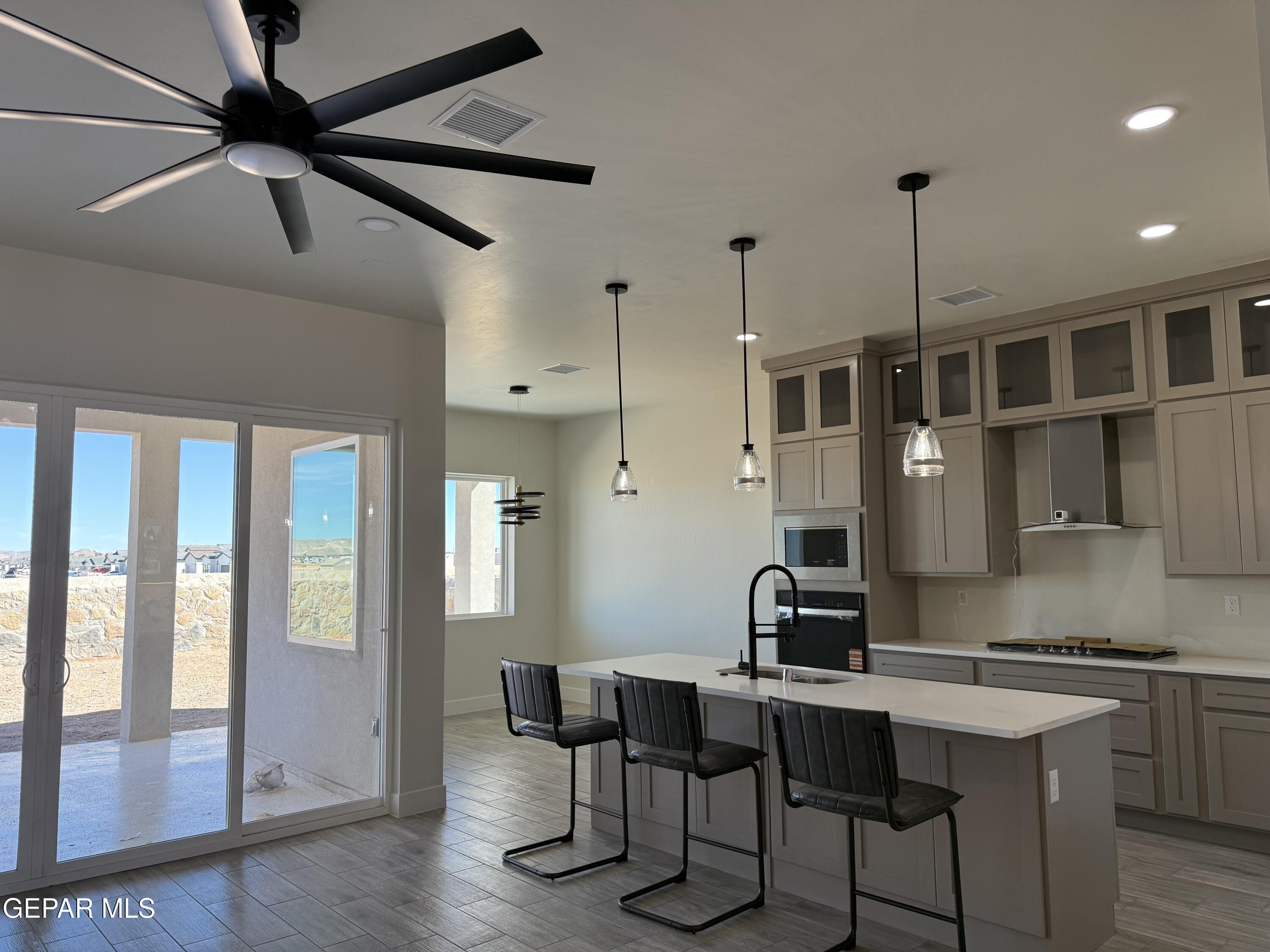 3904 Surmise Street El Paso, TX 79938 - Photo 4 of 21 a kitchen with a table chairs refrigerator and cabinets