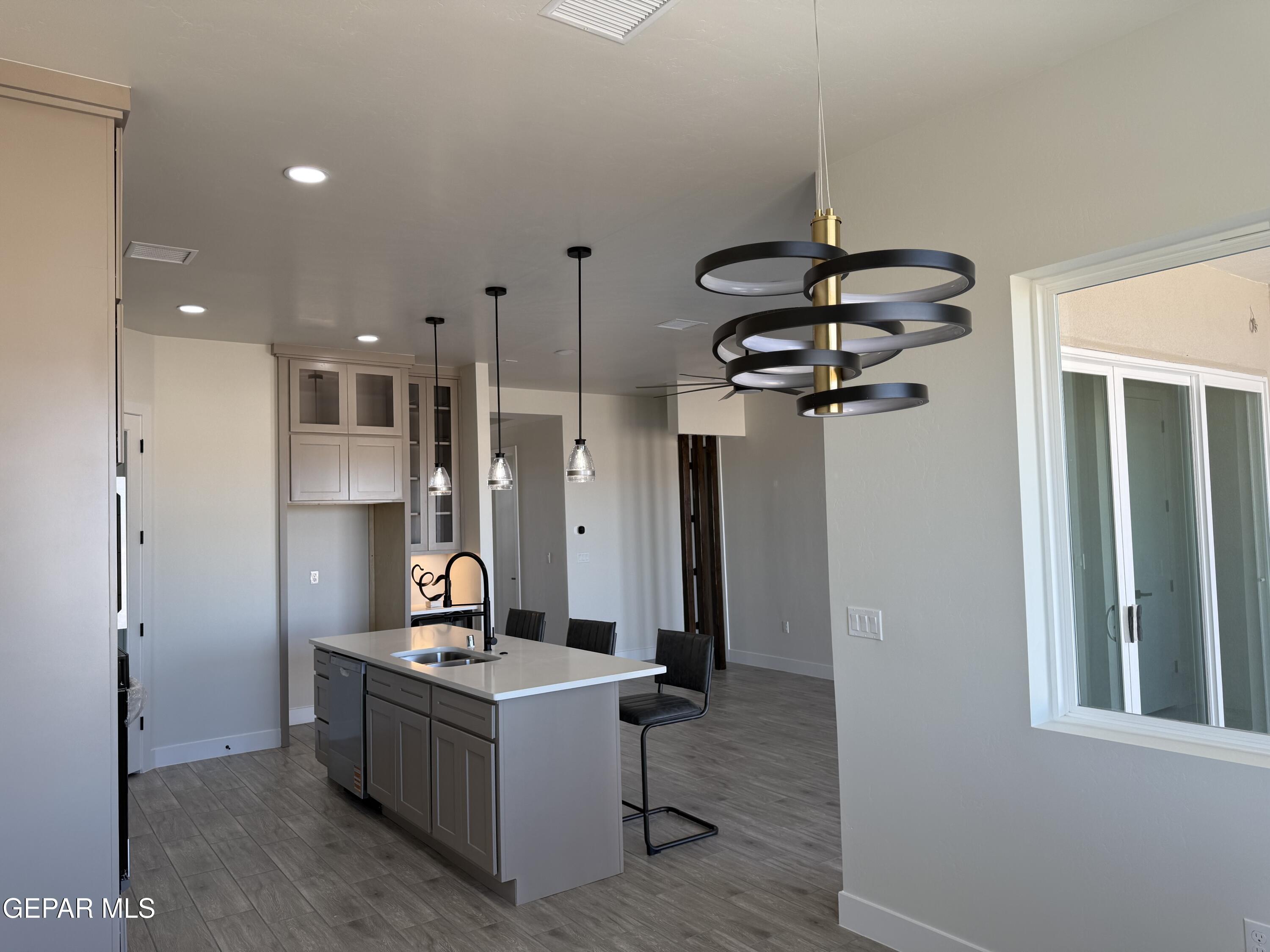 3904 Surmise Street El Paso, TX 79938 - Photo 6 of 21 a living room with stainless steel appliances kitchen island a table chairs in it and a window