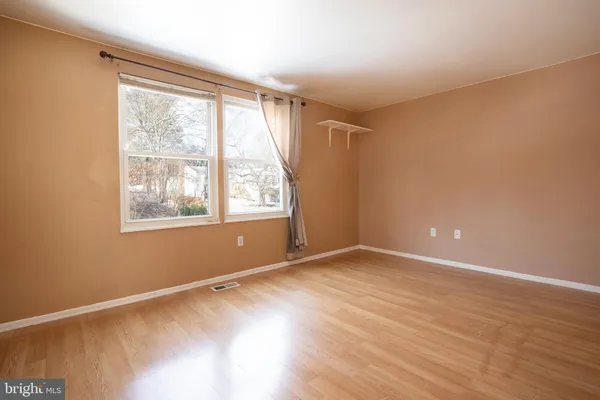 a view of a room with wooden floor and window