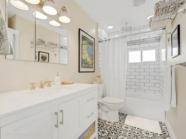 a bathroom with a sink a toilet a mirror a vanity and shower