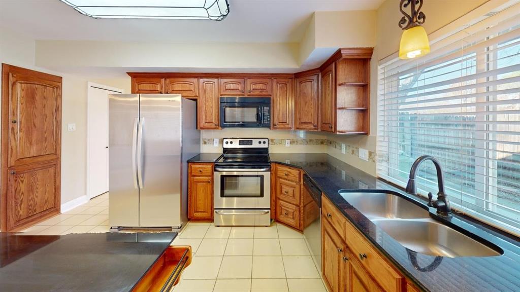 3005 Meandering Way Bedford, TX 76021 - Photo 4 of 22 a kitchen with stainless steel appliances a sink cabinets and a counter top space