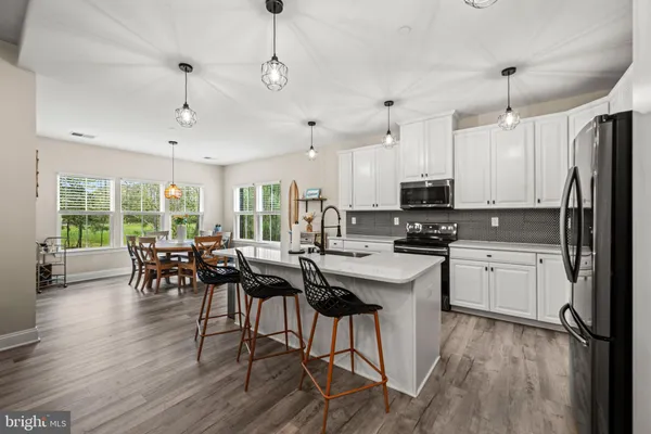 a dining room with furniture a chandelier and wooden floor