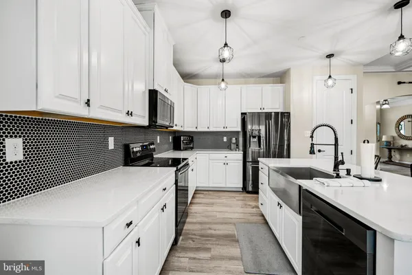 a kitchen with stainless steel appliances kitchen island granite countertop a stove a sink and a refrigerator