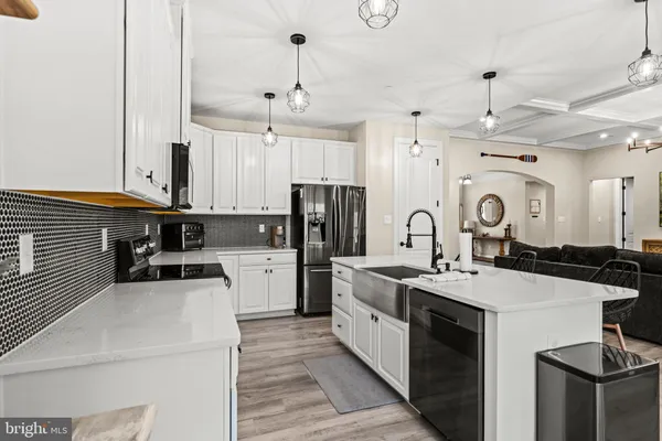 a kitchen with stainless steel appliances kitchen island granite countertop a stove top oven a sink dishwasher a dining table and chairs with wooden floor