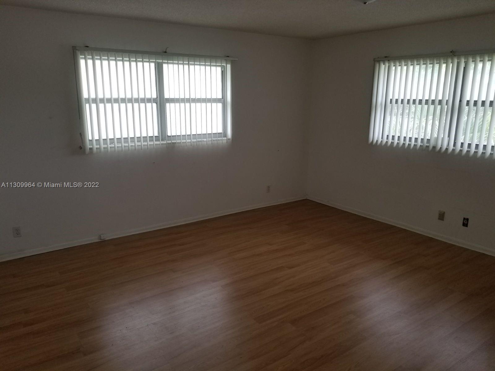 5790 Stirling Road, Unit 314 Hollywood, FL 33021 - Photo 6 of 9 an empty room with wooden floor and windows