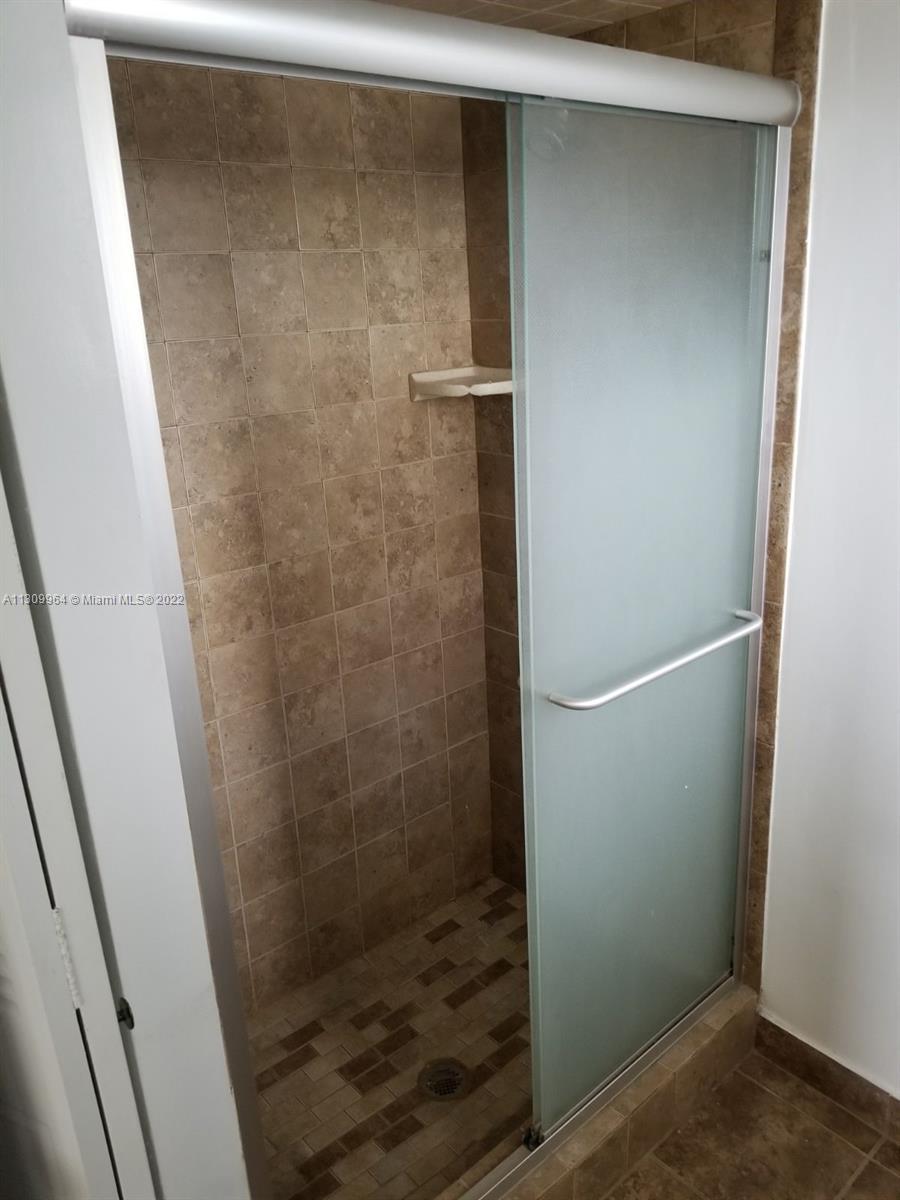 5790 Stirling Road, Unit 314 Hollywood, FL 33021 - Photo 7 of 9 a bathroom with a glass shower door