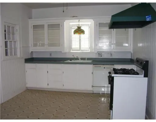 a kitchen with granite countertop a stove a sink and a microwave