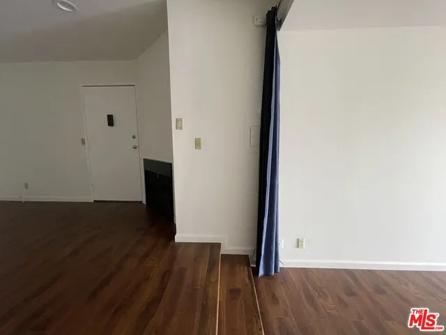a view of a room with wooden floor and bench