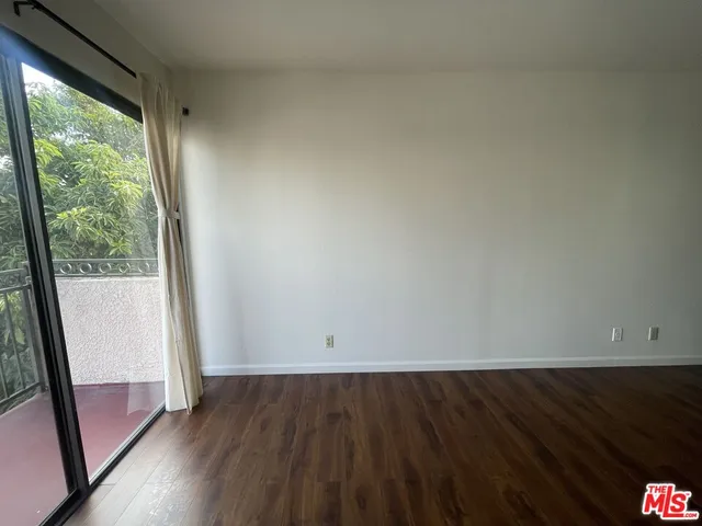an empty room with wooden floor and door