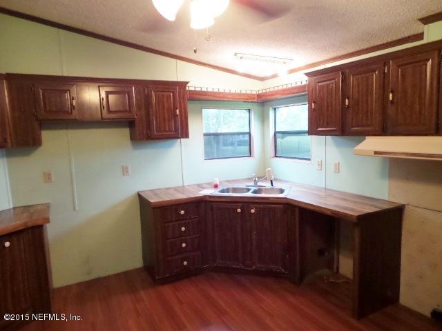 3150 Raulerson Road St. Augustine, FL 32092 - Photo 2 of 19 a kitchen with wooden cabinets and center island