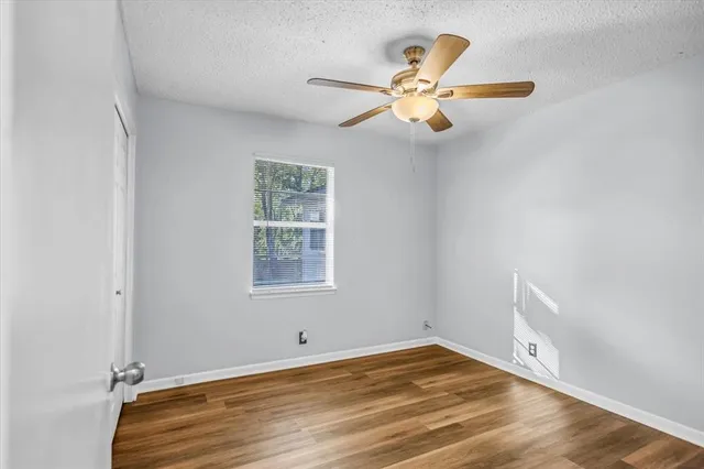 a view of empty room with window and wooden floor