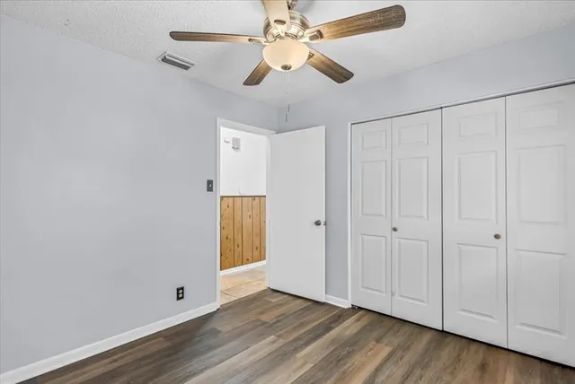 a view of an empty room with wooden floor