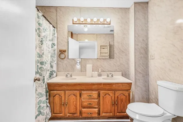 a bathroom with a sink a toilet and mirror