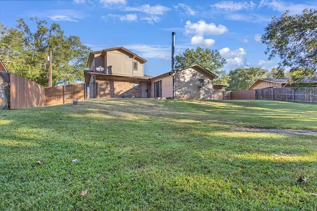 a view of a big yard with a house in the background