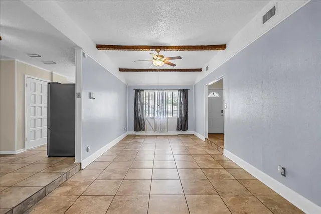 a view of hallway with a chandelier fan and a dining table chair