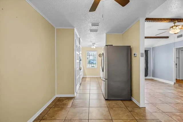 a view of a refrigerator in kitchen and an empty room