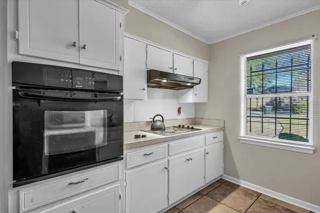 a kitchen with stainless steel appliances granite countertop white cabinets granite counter tops and a wooden floors