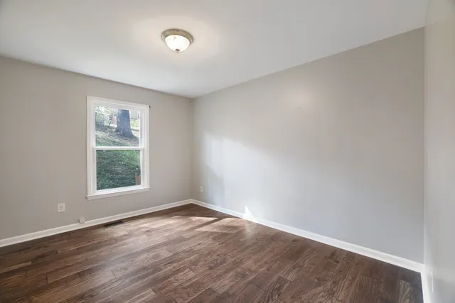 wooden floor in an empty room with a window