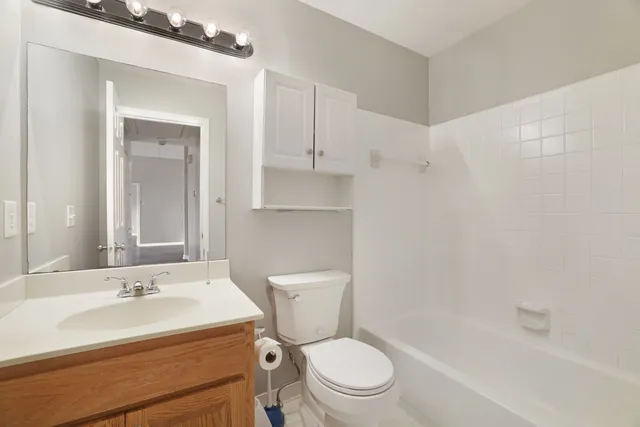 a bathroom with a sink toilet vanity and shower