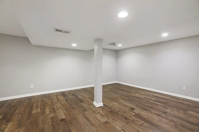 an empty room with wooden floor and entrance