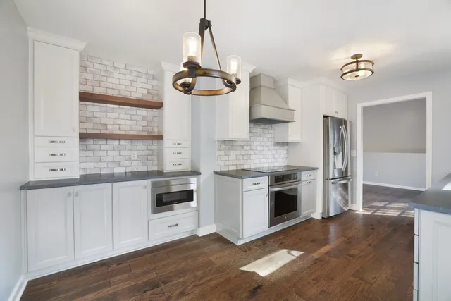 a kitchen with stainless steel appliances granite countertop a stove and a sink