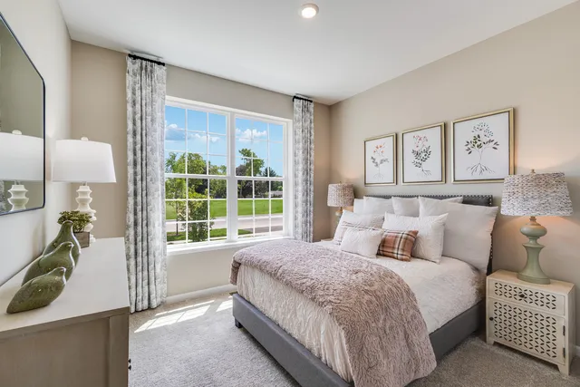 a spacious bedroom with a bed and a large window