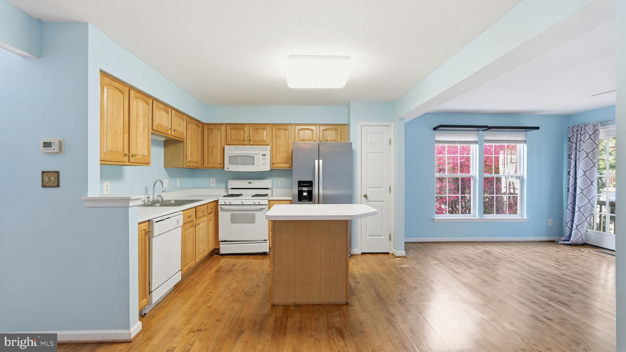 14431 Colonel Wood Road Gainesville, VA 20155 - Photo 17 of 37 a kitchen with stainless steel appliances granite countertop a stove top oven a sink dishwasher and a refrigerator with wooden floor