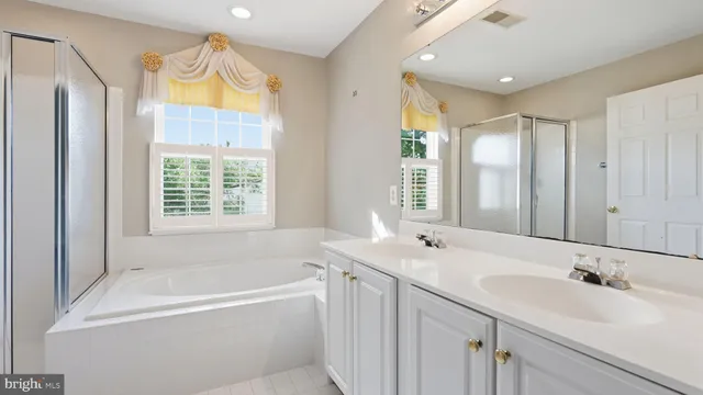 a bathroom with a tub sink and mirror