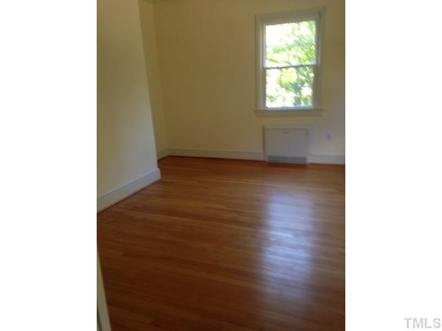 1569 Longs Store Road Roxboro, NC 27574 - Photo 12 of 22 a view of an empty room with wooden floor and a window