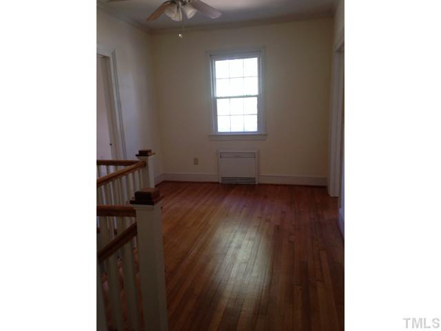 1569 Longs Store Road Roxboro, NC 27574 - Photo 13 of 22 a view of an empty room with wooden floor and a window