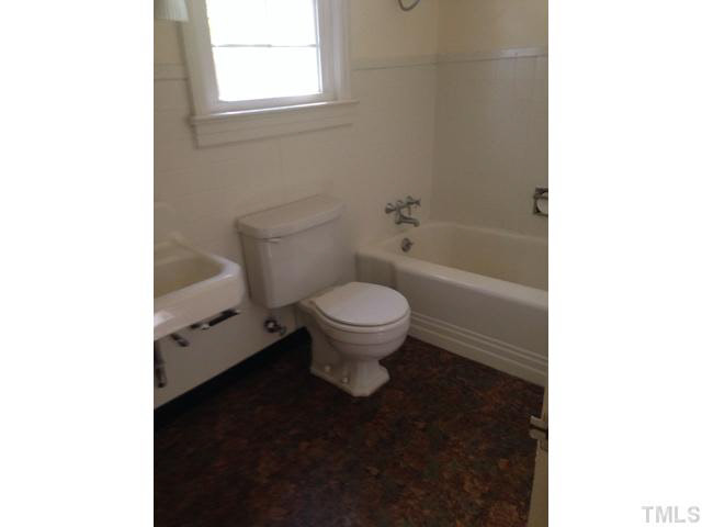 1569 Longs Store Road Roxboro, NC 27574 - Photo 14 of 22 a white toilet sitting next to a bathroom sink and a tub