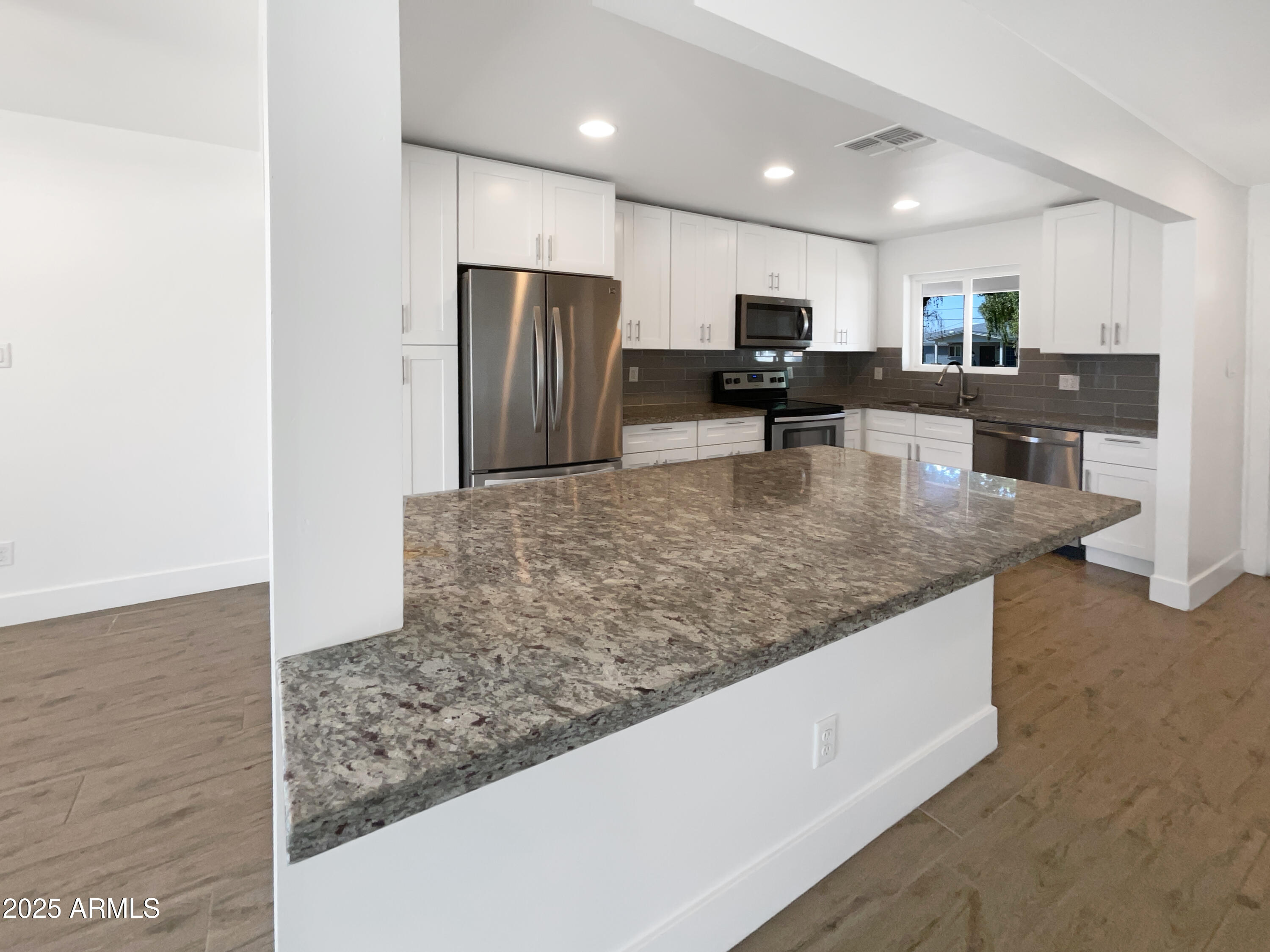 7231 North 23rd Avenue Phoenix, AZ 85021 - Photo 10 of 28 a kitchen with stainless steel appliances granite countertop a refrigerator a stove and a sink