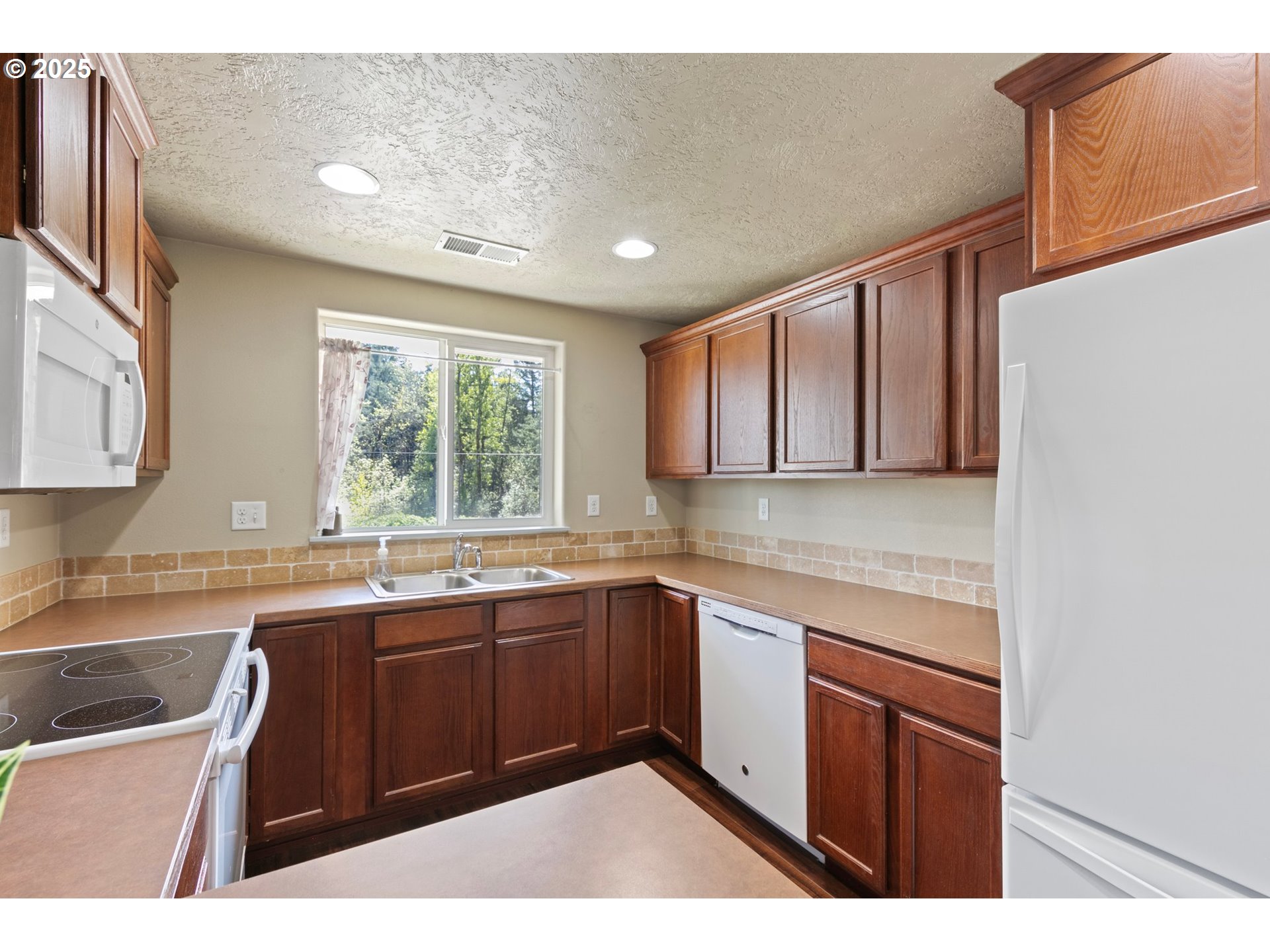 4912 Holly Street Springfield, OR 97478 - Photo 11 of 37 a kitchen with a sink window and cabinets